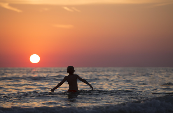 Man seeing sunset in beach.