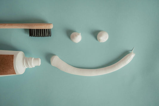 A tooth paste near tooth brush making a smily face.